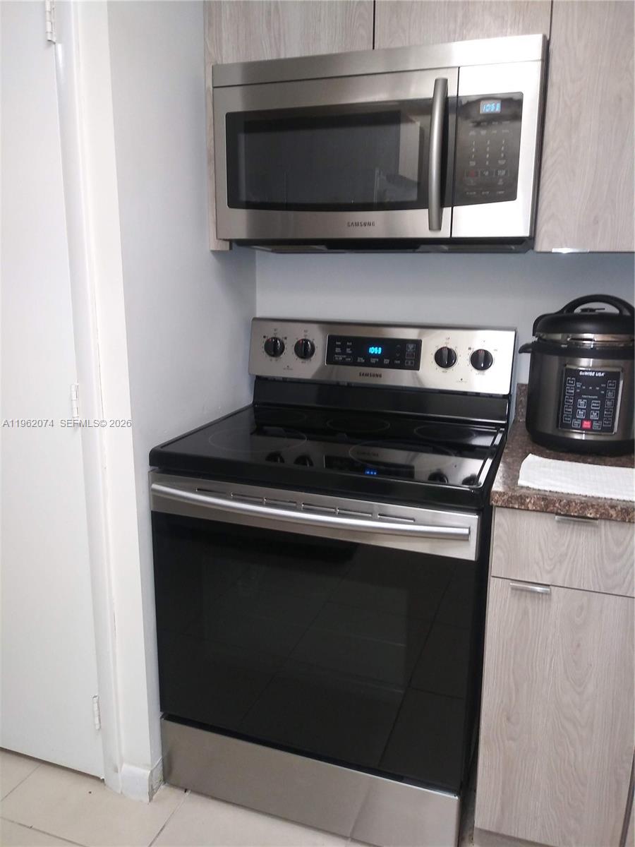 A kitchen features a stainless steel Samsung microwave and range with light wood cabinets — 4172 Inverrary Dr # 310, Lauderhill FL 33319, LAUDERHILL, FL
