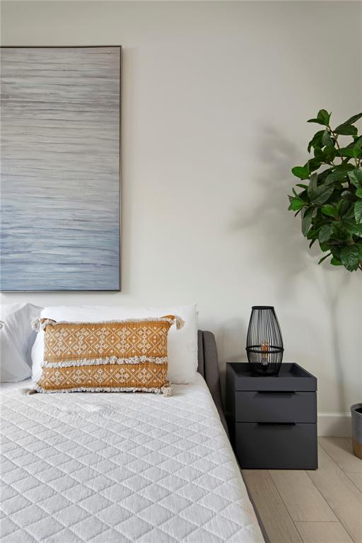 A bedroom features a bed with a patterned pillow, a dark nightstand, and wall art — 4919 N NEBRASKA AVENUE, TAMPA, FL