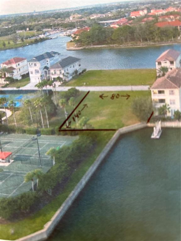 An aerial view shows a vacant waterfront lot with marked dimensions next to tennis courts — 237 and 239 YACHT HARBOR DR, PALM COAST, FL