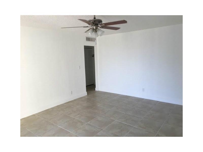 An empty room with white walls, tiled flooring, and a ceiling fan — 4003 N University Drive # 107, Sunrise FL 33351, SUNRISE, FL