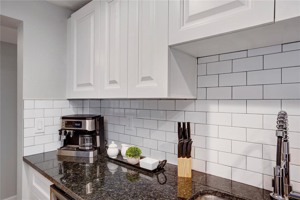 A kitchen counter features a coffee maker, knife block, and white subway tile backsplash — 4705 HOLLINGSWORTH AVENUE UNIT Lower, SARASOTA, FL