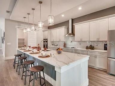 A modern kitchen with white cabinetry and a large island opens to a backyard patio — 200 E GRANT STREET, ORLANDO, FL