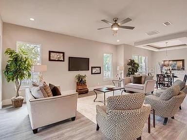 A modern kitchen features a large marble-topped island, white cabinetry, and stainless steel appliances — 200 E GRANT STREET, ORLANDO, FL