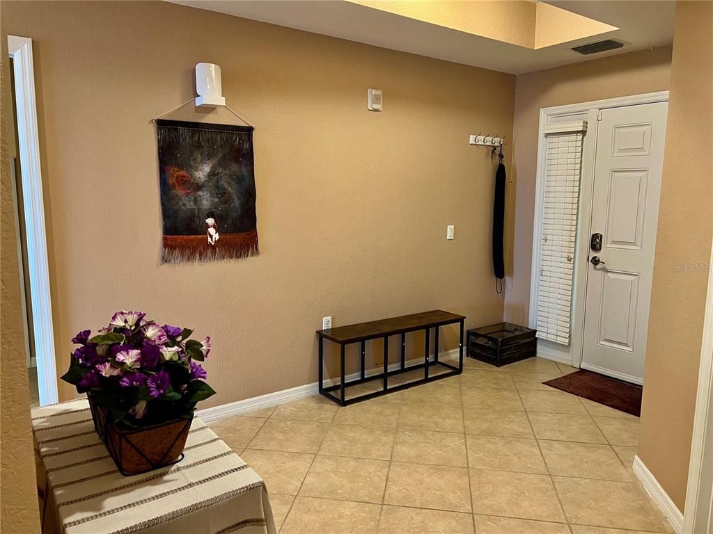 An entryway features tile flooring, a bench, a wall hanging, and a white front door — 1188 N TAMIAMI TRAIL UNIT 403, SARASOTA, FL