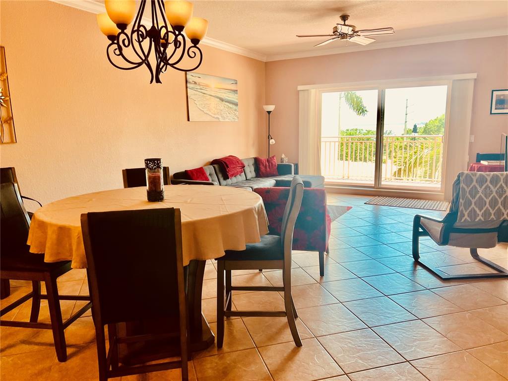 A dining area with a round table sits in front of a living room with tile floors — 1188 N TAMIAMI TRAIL UNIT 403, SARASOTA, FL