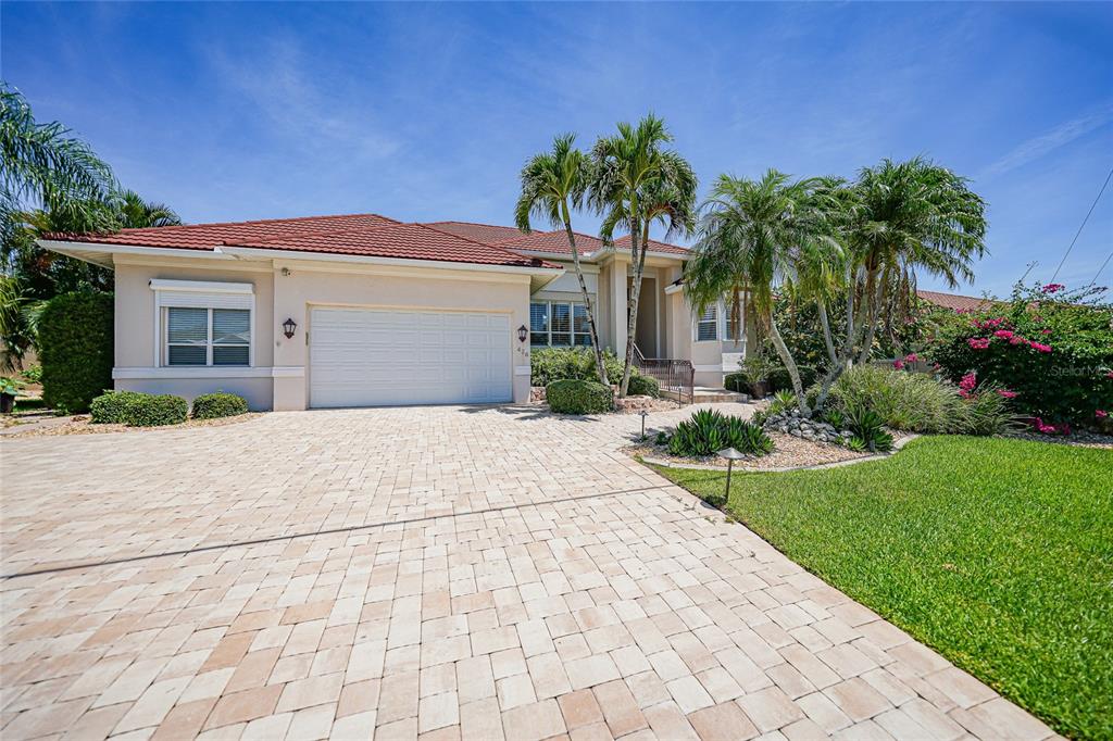 A single-story house with a red tile roof, a paved driveway, and palm trees — 436 VALLETTA COURT, PUNTA GORDA, FL