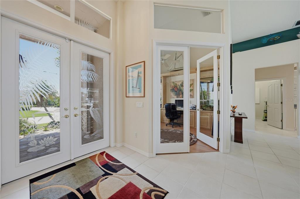 An entryway with tiled floors, double glass front doors, and French doors leading to an office — 436 VALLETTA COURT, PUNTA GORDA, FL
