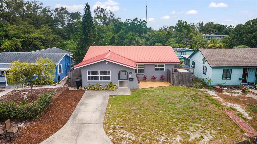 An aerial view shows a gray house with a red metal roof and a driveway — 6250 5TH AVENUE S, ST PETERSBURG, FL