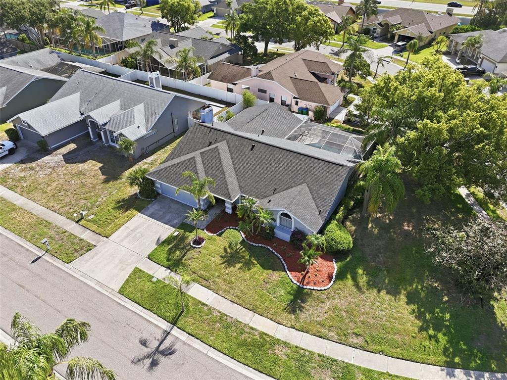 An aerial view shows a suburban house with a gray roof and a screened-in pool — 1775 STABLE TRAIL, PALM HARBOR, FL