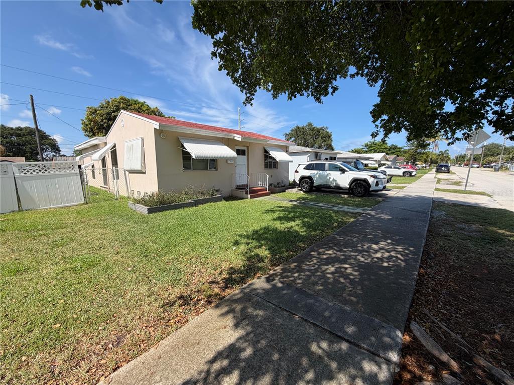A single-story house with a red roof, beige stucco walls, and a white fence — 2447 ARTHUR STREET, HOLLYWOOD, FL