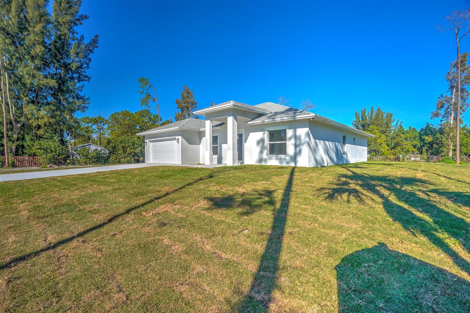 A white, single-story house with a two-car garage sits on a grassy lot — 13875 63rd Lane N, FL 33470, FL