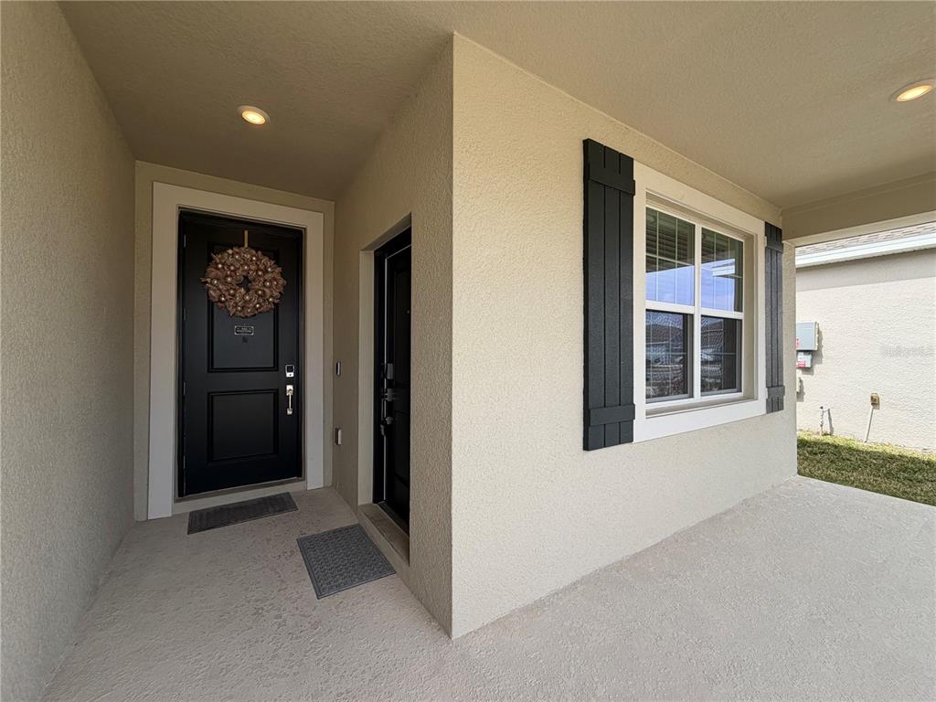 A covered front porch features a black front door, a side door, and a window — 652 GROVE STREET, WINTER HAVEN, FL