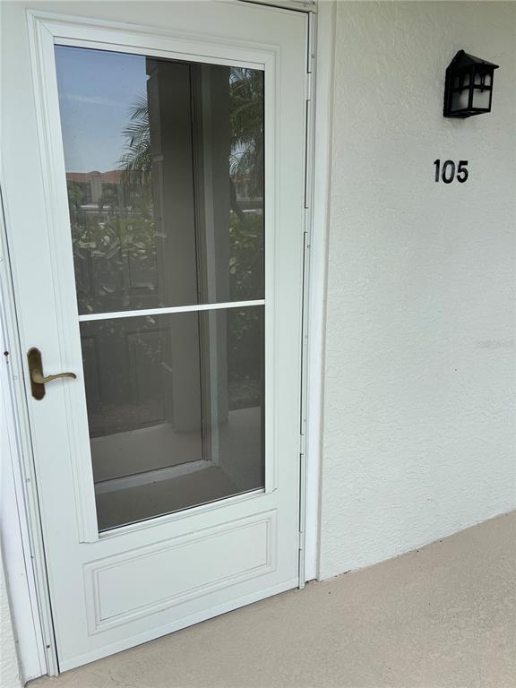 A white exterior door with a screen insert and the number 105 on the wall — 6507 STONE RIVER ROAD UNIT 105, BRADENTON, FL