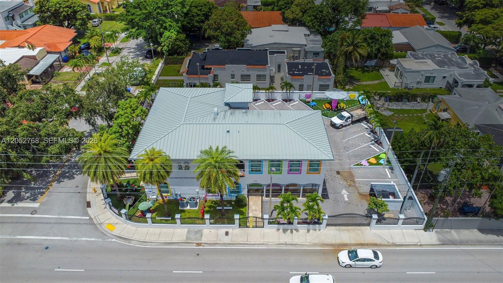 An aerial view shows a commercial building with a metal roof, parking lot, and playground — 2280 SW 17th Ave, Miami FL 33145, MIAMI, FL