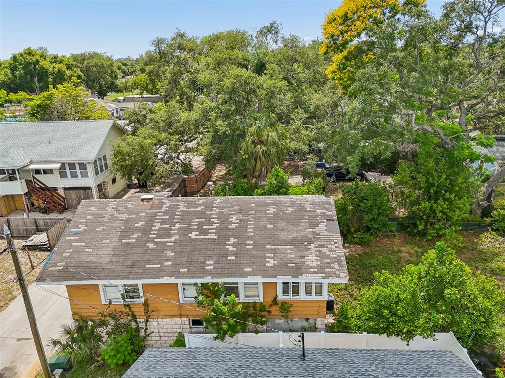 An aerial view shows a two-story house with a weathered roof and yellow siding — 2210 20TH AVENUE S, ST PETERSBURG, FL