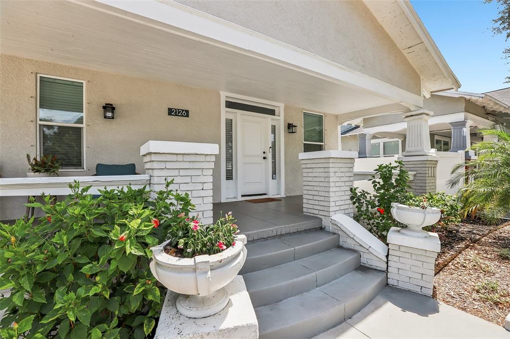 A single-story house with a covered front porch, brick columns, and a white retaining wall — 2126 W BEACH STREET, TAMPA, FL