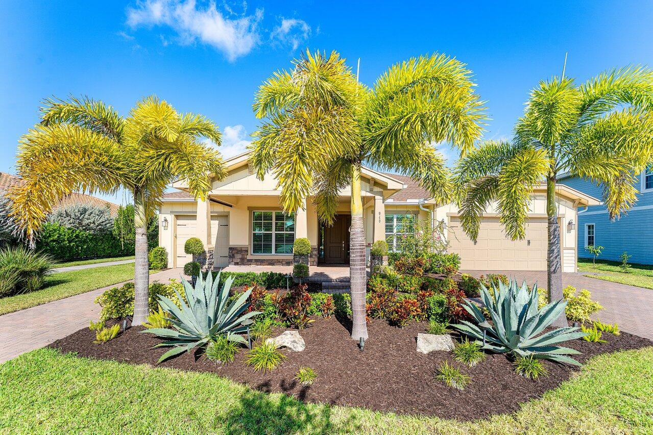 A single-story house with a beige exterior, palm trees, and a landscaped front yard — 940 Hookline Circle, Loxahatchee FL 33470, LOXAHATCHEE, FL