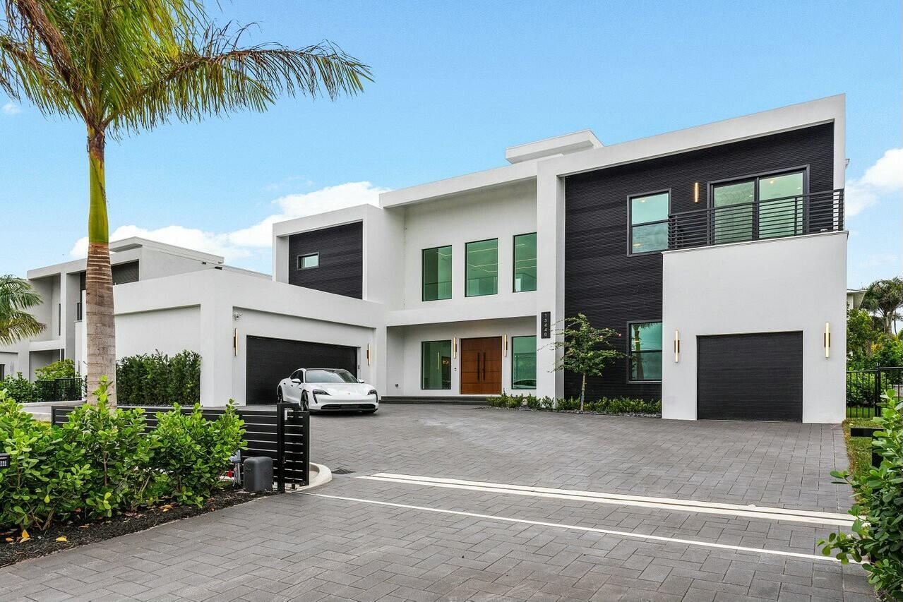 A modern two-story house with a white and black exterior, a paved driveway, and a car — 13440 Us Highway 1, Juno Beach FL 33408, JUNO BEACH, FL