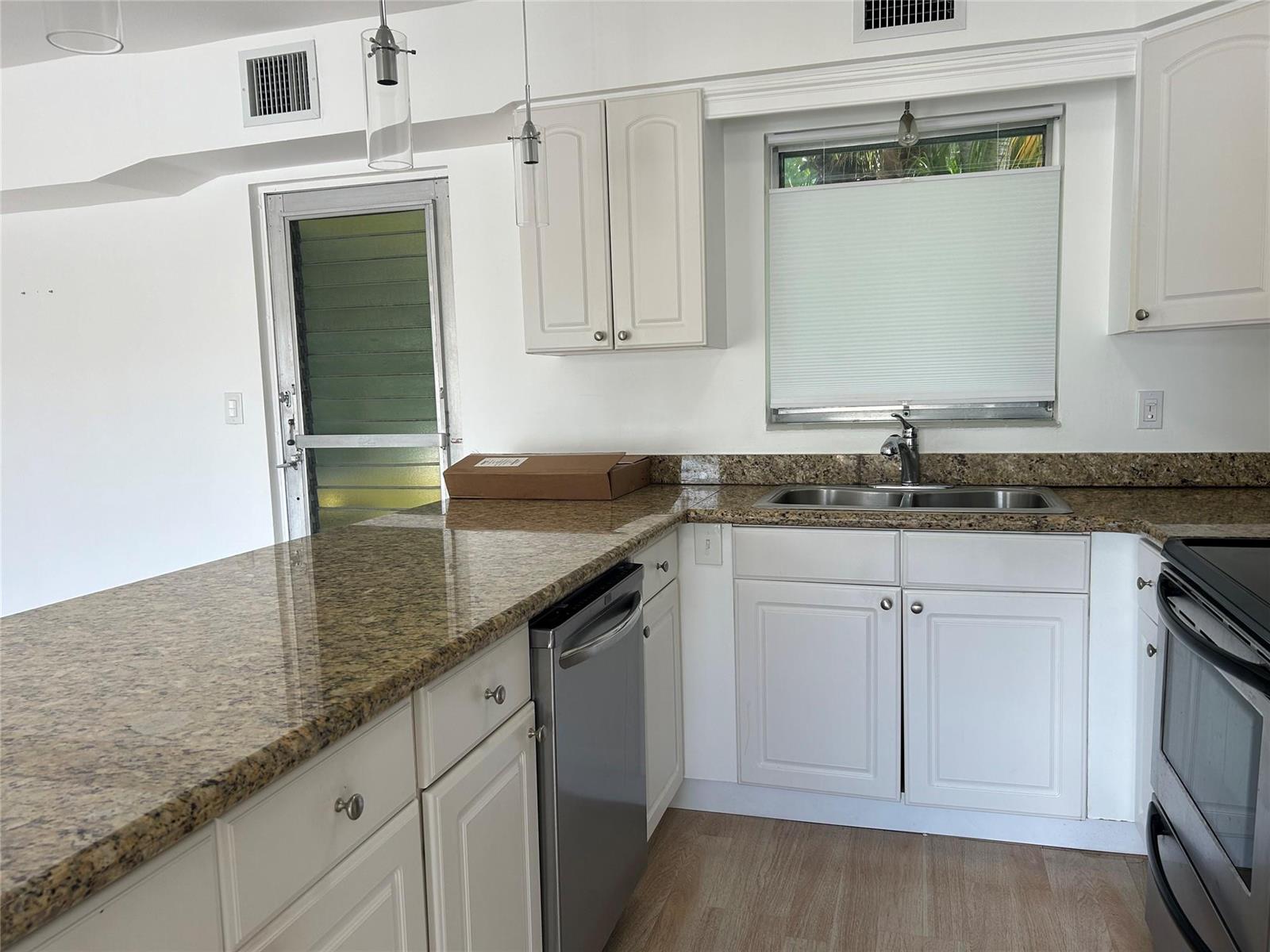 A kitchen features white cabinets, granite countertops, stainless steel appliances, and a window above the sink — 77 Hendricks Isle # 10, Fort Lauderdale FL 33301, FORT LAUDERDALE, FL