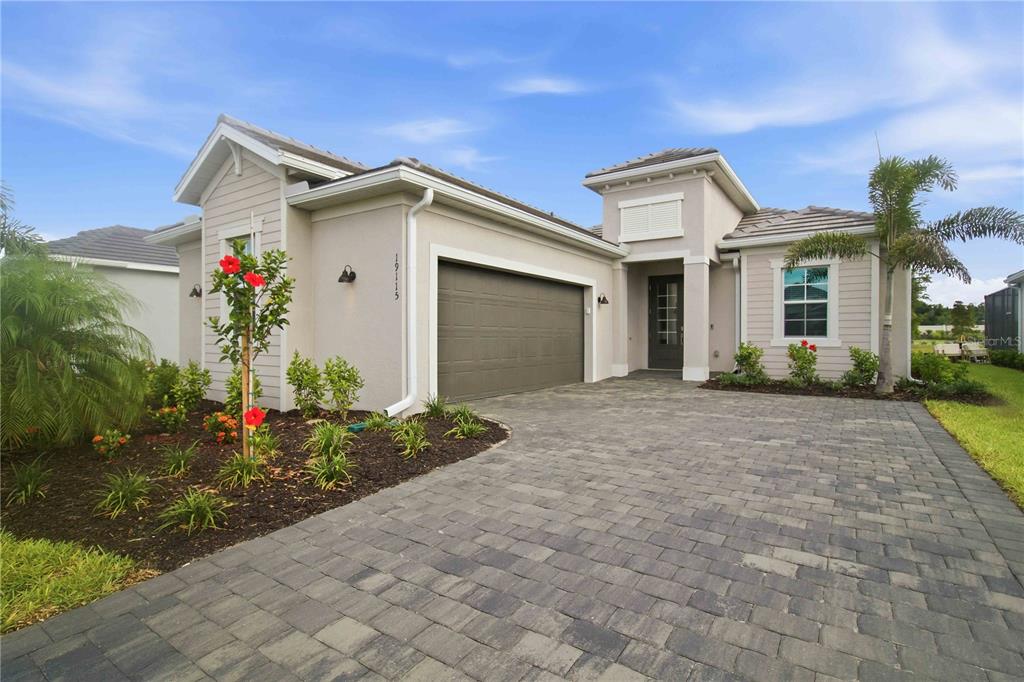 A single-story house with a paved driveway, two-car garage, and a small front garden — 19115 CHERRYSTONE WAY, LAKEWOOD RANCH, FL