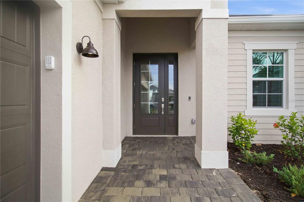 A paved walkway leads to a dark brown front door under a covered porch — 19115 CHERRYSTONE WAY, LAKEWOOD RANCH, FL