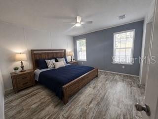 A dining area with wood-look flooring, white walls, gray wainscoting, and a small table — 55515 LISA STREET, ASTOR, FL