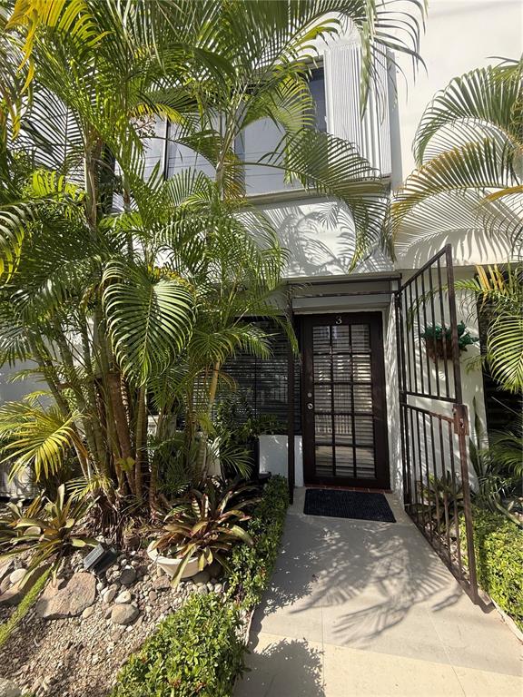 The exterior entrance of a building features a glass-paned door, palm trees, and landscaping — 1158 MAGDALENA UNIT 3, SAN JUAN, PR
