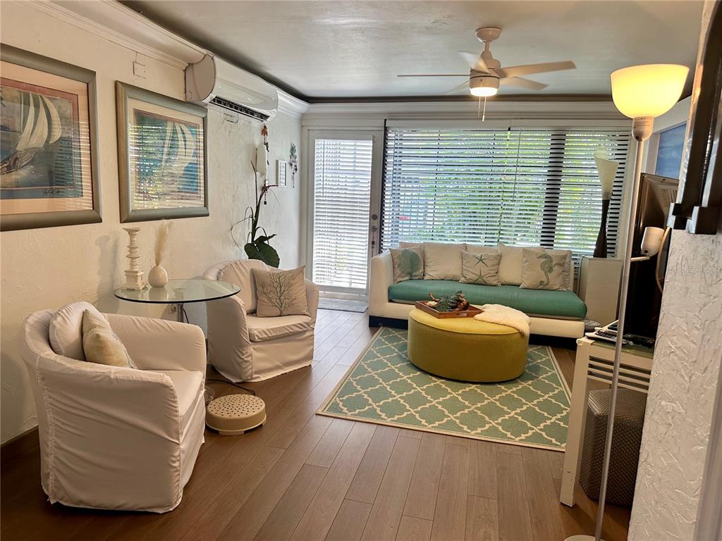 A living room features a white sofa, two armchairs, a round ottoman, and wood flooring — 1158 MAGDALENA UNIT 3, SAN JUAN, PR