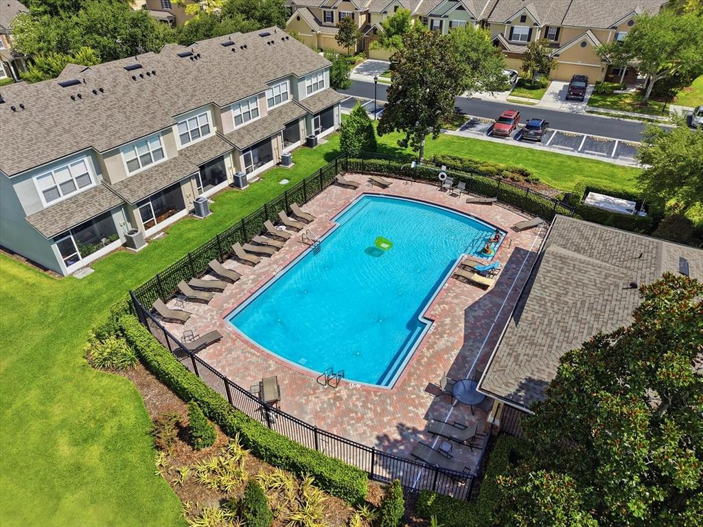 An aerial view shows a rectangular swimming pool surrounded by a brick deck and fence — 4611 POND RIDGE DRIVE, RIVERVIEW, FL