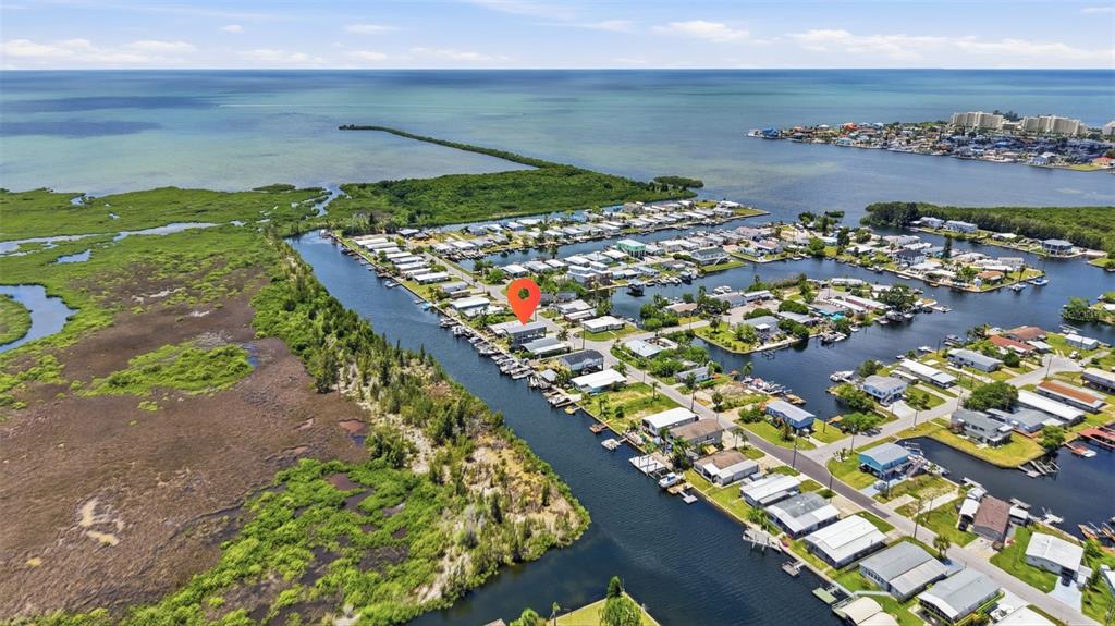 An aerial view shows a waterfront neighborhood with a red location pin on a house — 6310 TOWER DRIVE, HUDSON, FL
