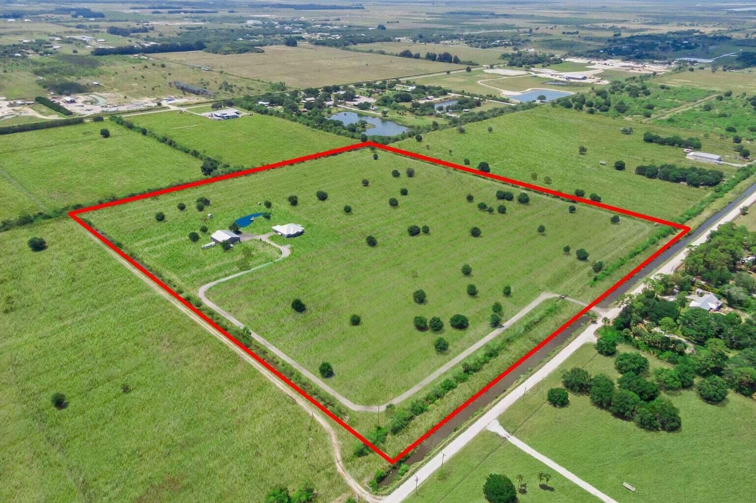 An aerial view shows a large, rectangular grassy lot outlined in red with a house — 1545 Pulitzer Road, Fort Pierce FL 34945, FORT PIERCE, FL