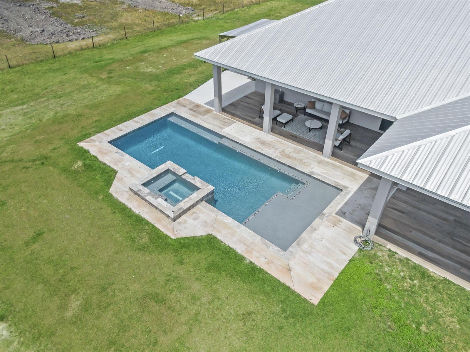 An aerial view of a rectangular swimming pool with an attached spa and patio — 1545 Pulitzer Road, Fort Pierce FL 34945, FORT PIERCE, FL
