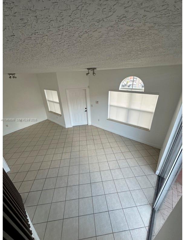 An empty room with white walls, tiled floors, a front door, and two windows — 11438 NW 62nd Ter # 226, Doral FL 33178, DORAL, FL