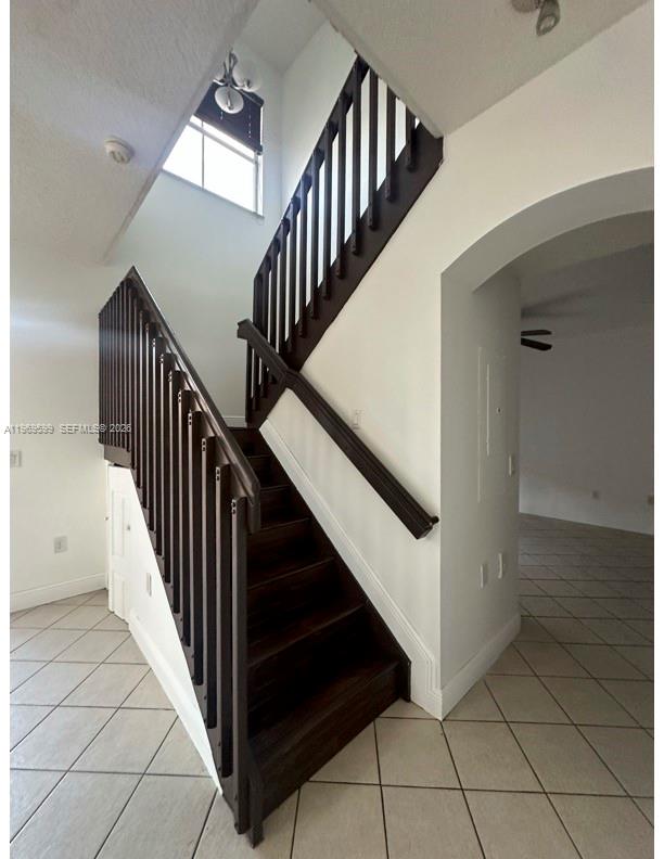 A staircase with dark wood railings and steps sits in a white-walled entryway — 11438 NW 62nd Ter # 226, Doral FL 33178, DORAL, FL