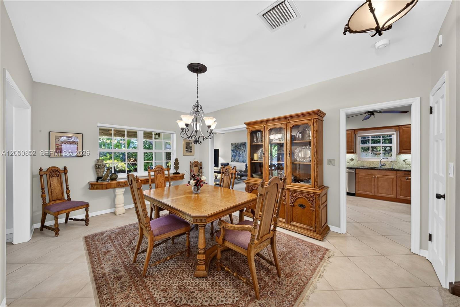 A dining room features a wooden table, chairs with purple cushions, and a large hutch — 4820 Campo Sano Ct, Coral Gables FL 33146, CORAL GABLES, FL