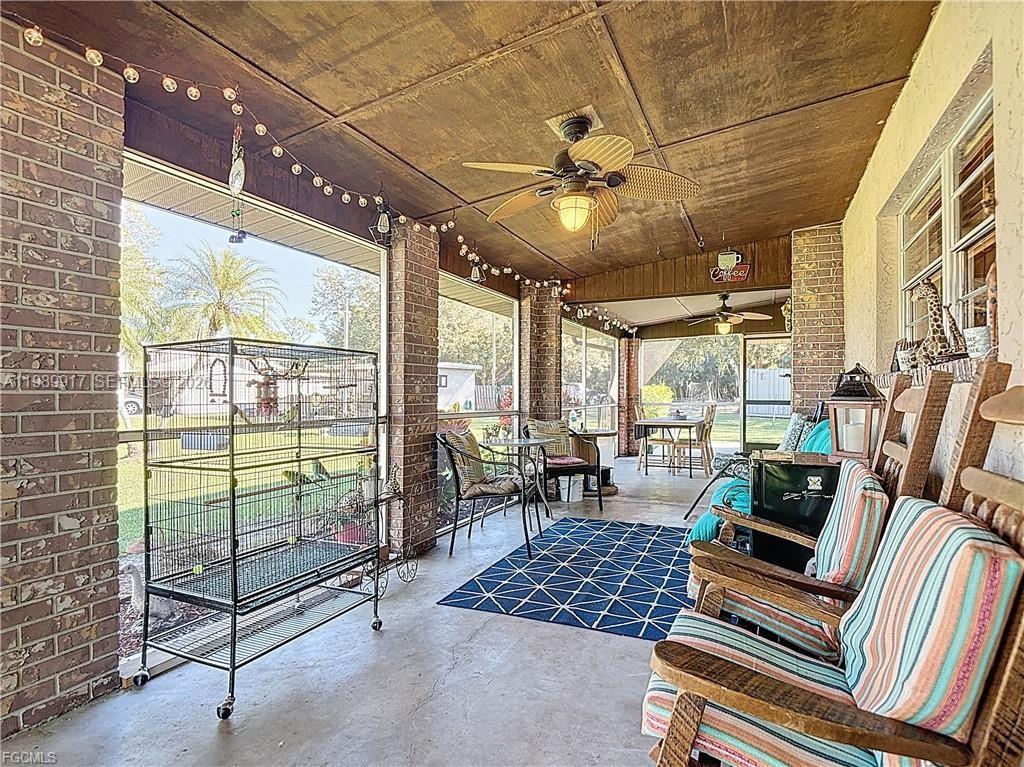 A screened-in porch features brick walls, a wood-paneled ceiling, a ceiling fan, and furniture — 0 Loblolly Bay Rd, FL 33935, FL