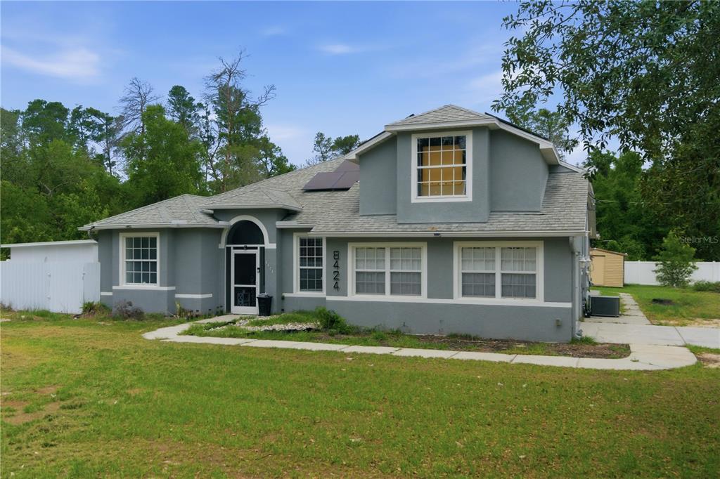 A two-story gray house with a front porch and a large lawn — 8424 BALM STREET, WEEKI WACHEE, FL
