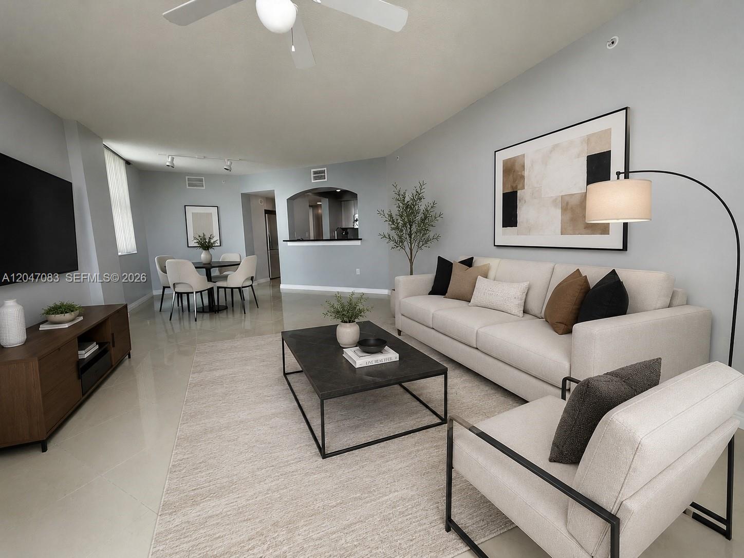 A modern living room features a light-colored sofa, a dark coffee table, and tile flooring — 9201 Collins Ave # 521, Surfside FL 33154, SURFSIDE, FL