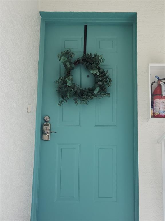 A teal front door with a wreath and a digital keypad lock — 6503 FAIRWAY GARDENS DRIVE, BRADENTON, FL