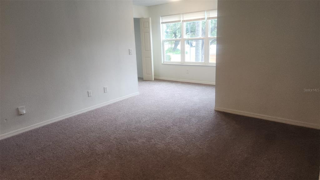 An empty room with beige carpet, white walls, and a window with blinds — 4540 COMMANDER DRIVE UNIT 2224, ORLANDO, FL