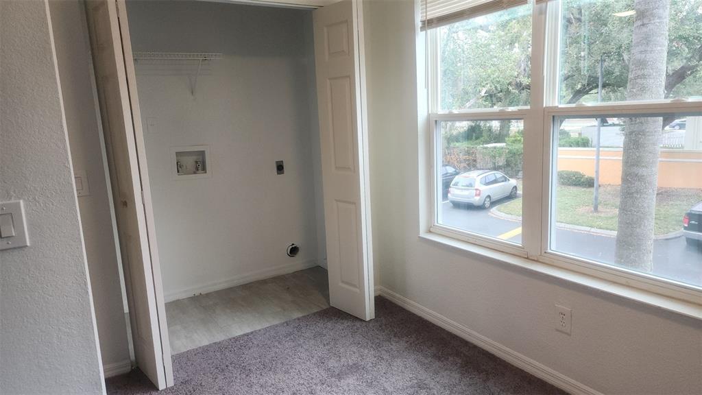 A room with gray carpet, a window, and a closet containing laundry hookups — 4540 COMMANDER DRIVE UNIT 2224, ORLANDO, FL