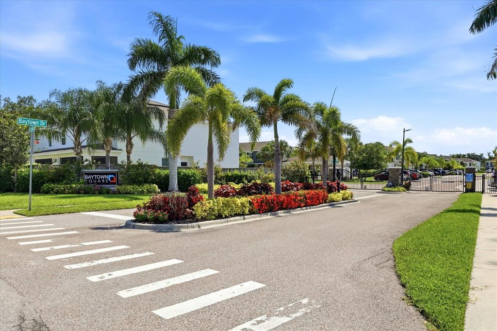 The entrance to a residential community features a gated driveway, palm trees, and landscaping — 6453 BAYTOWN DRIVE, SARASOTA, FL