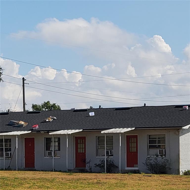 A single-story building with a dark shingled roof, red doors, and white window awnings — 1002 DANIELS STREET, DUNDEE, FL