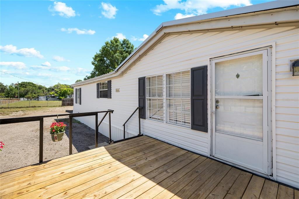 A wooden deck leads to the white siding exterior of a manufactured home — 12507 ICEWOOD COURT, RIVERVIEW, FL