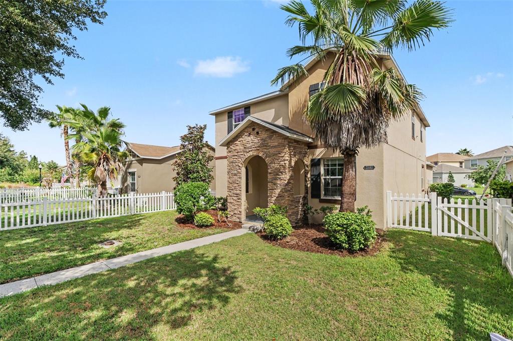 A two-story house with a stone-accented entryway, a palm tree, and a white picket fence — 21087 PLEASANT PLAINS PARKWAY, LAND O LAKES, FL
