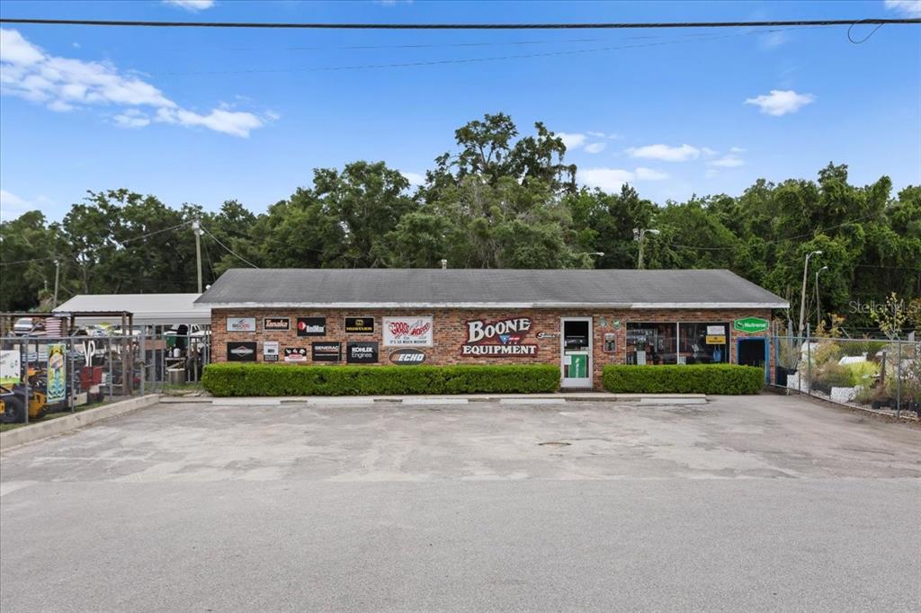 The exterior of a brick commercial building features signage for Boone Equipment and various brands — 17962 NW US HIGHWAY 441, HIGH SPRINGS, FL