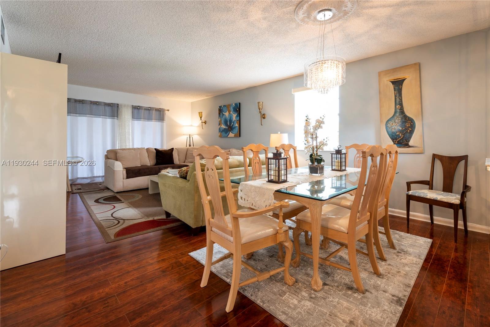 A balcony with a brown door, metal railing, and a view of trees — 4940 E Sabal Palm Blvd # 414, Tamarac FL 33319, TAMARAC, FL