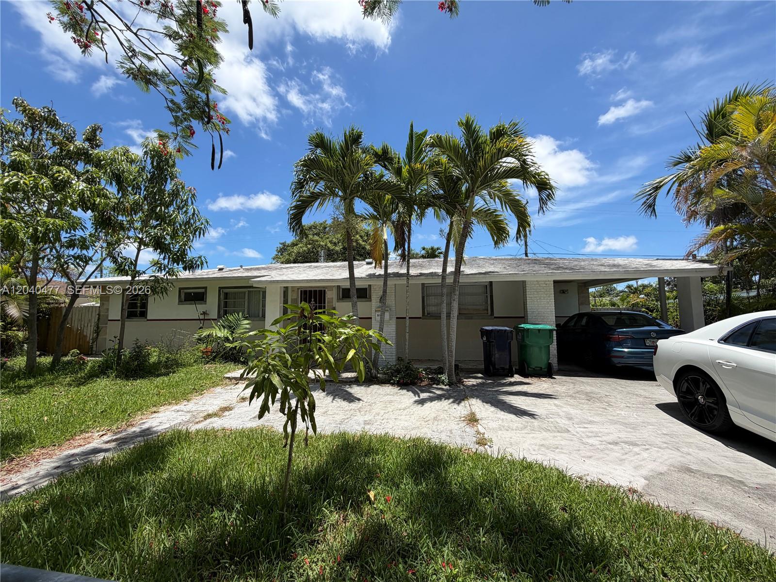 A single-story house with a concrete driveway, palm trees, and a carport under a blue sky — 9110 SW 44th St, Miami FL 33165, MIAMI, FL