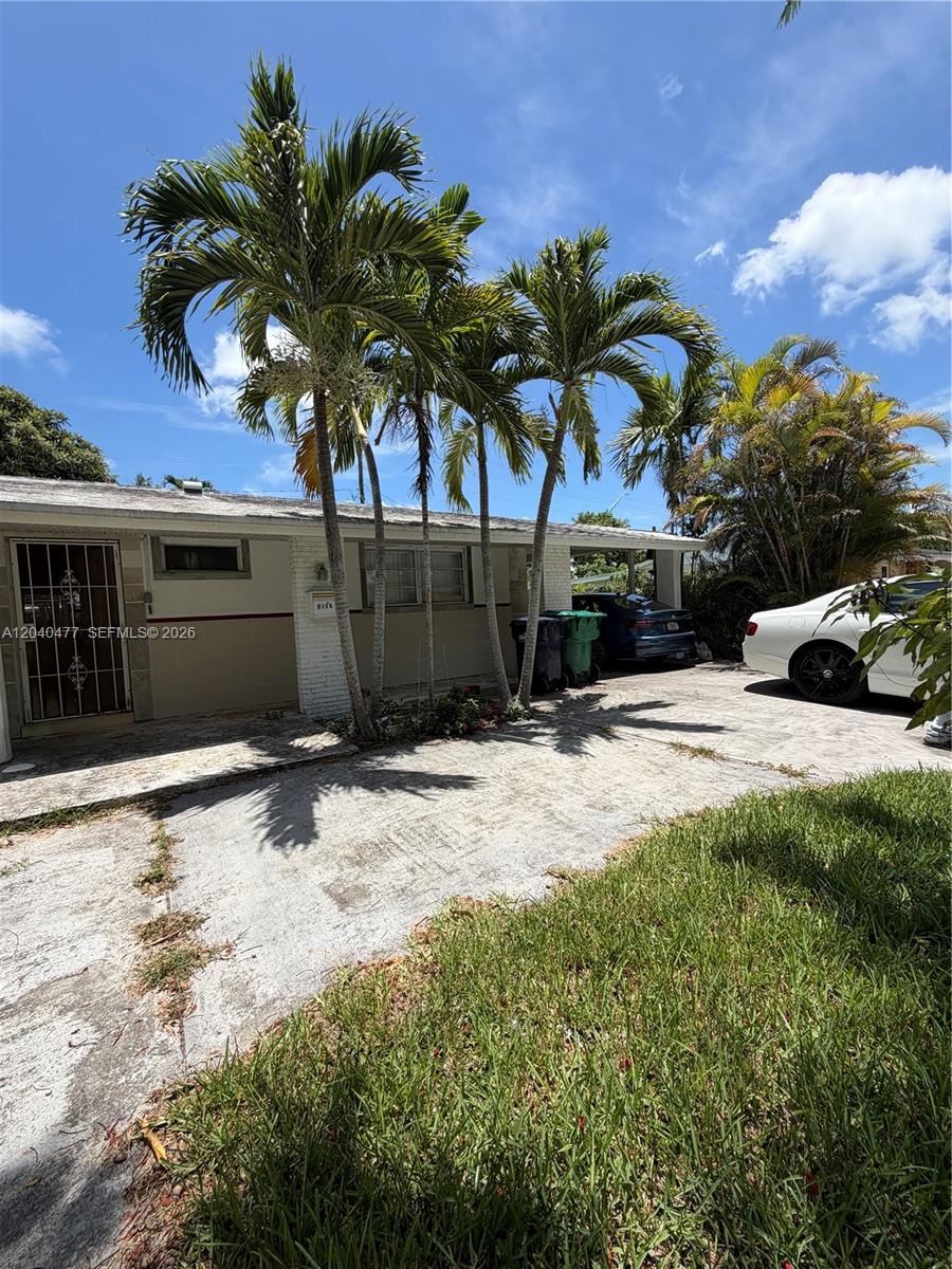 The exterior of a single-story house features a concrete driveway, palm trees, and parked cars — 9110 SW 44th St, Miami FL 33165, MIAMI, FL