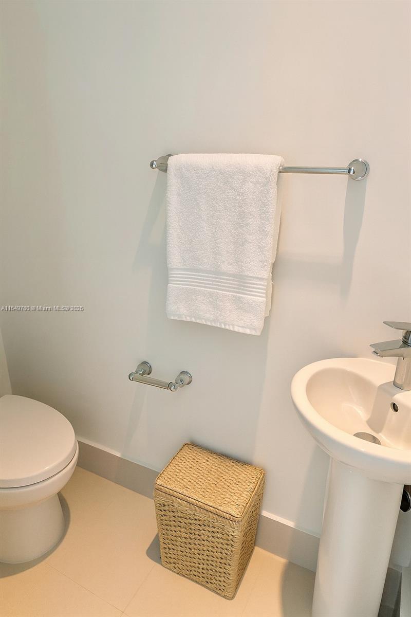 A bathroom features a pedestal sink, a toilet, and a towel rack with a white towel — 501 NE 31st St # 3004, Miami FL 33137, MIAMI, FL